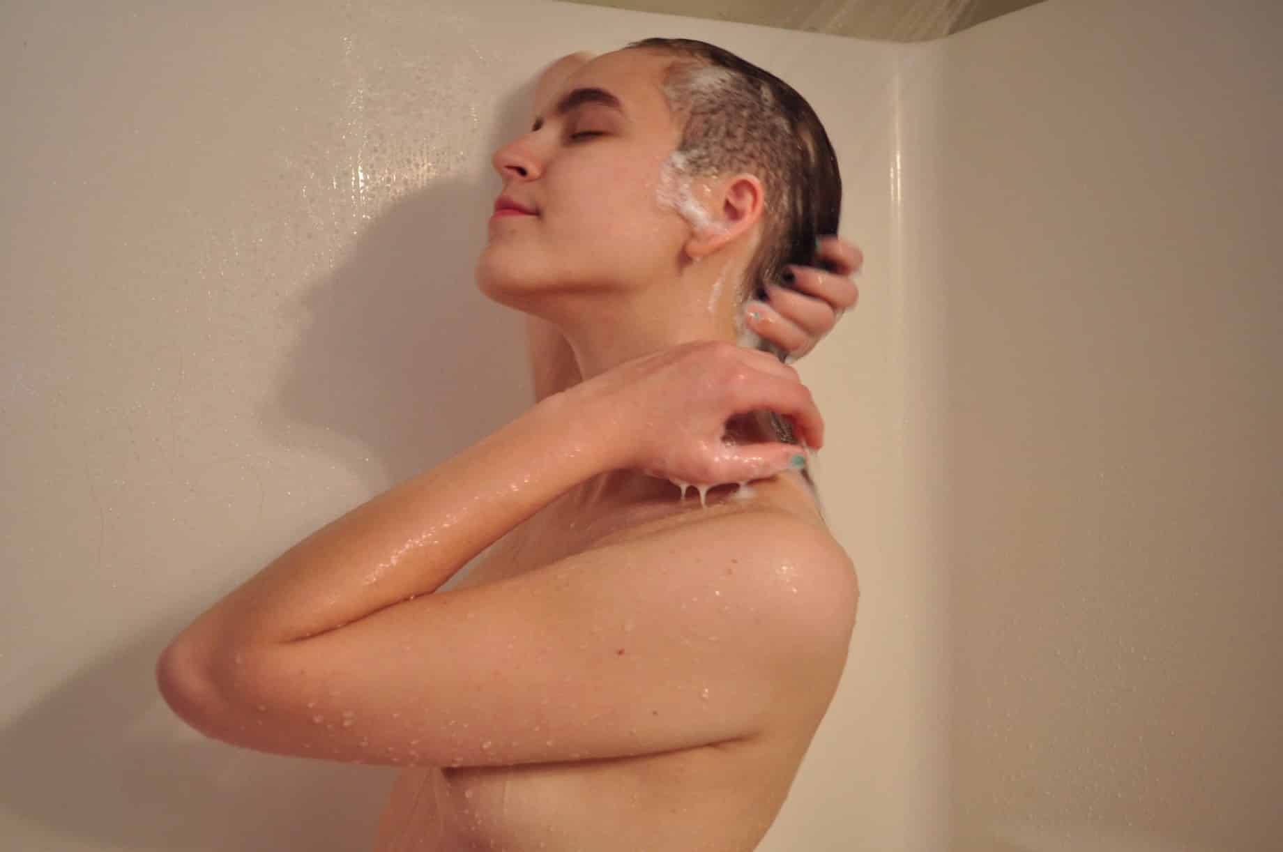 Jeune femme aux cheveux courts passe sous la douche c'est sexy !