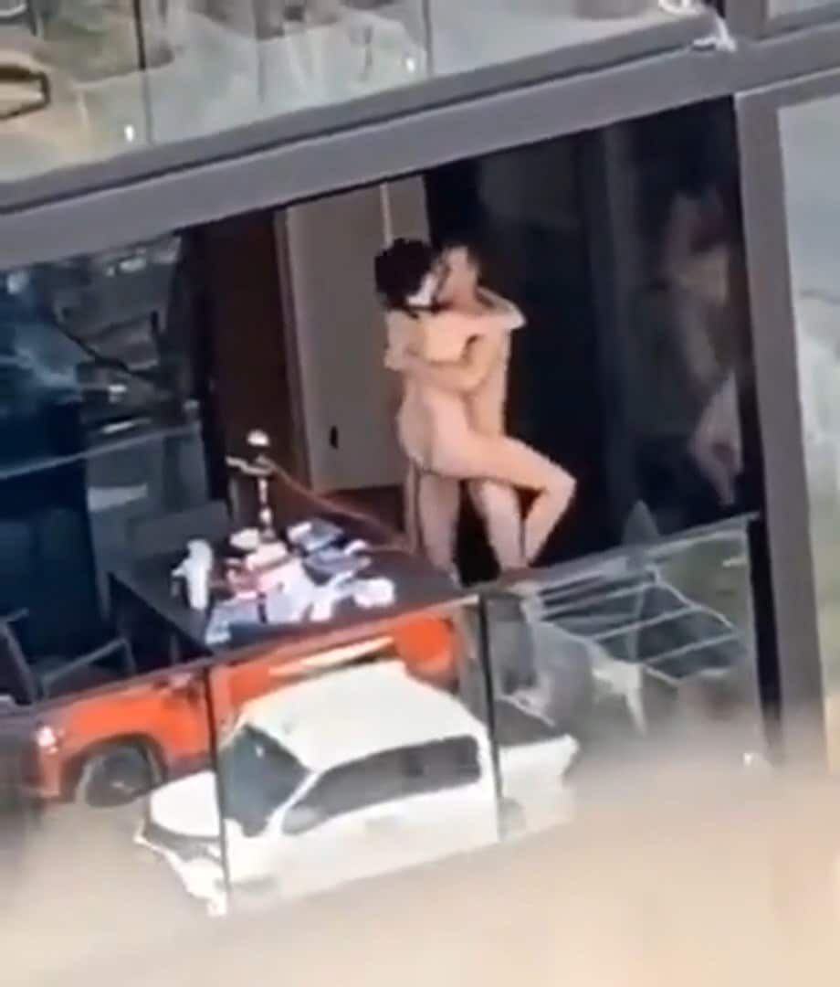 Un couple baise à la fenêtre avec des ouvriers à l'immeuble en face