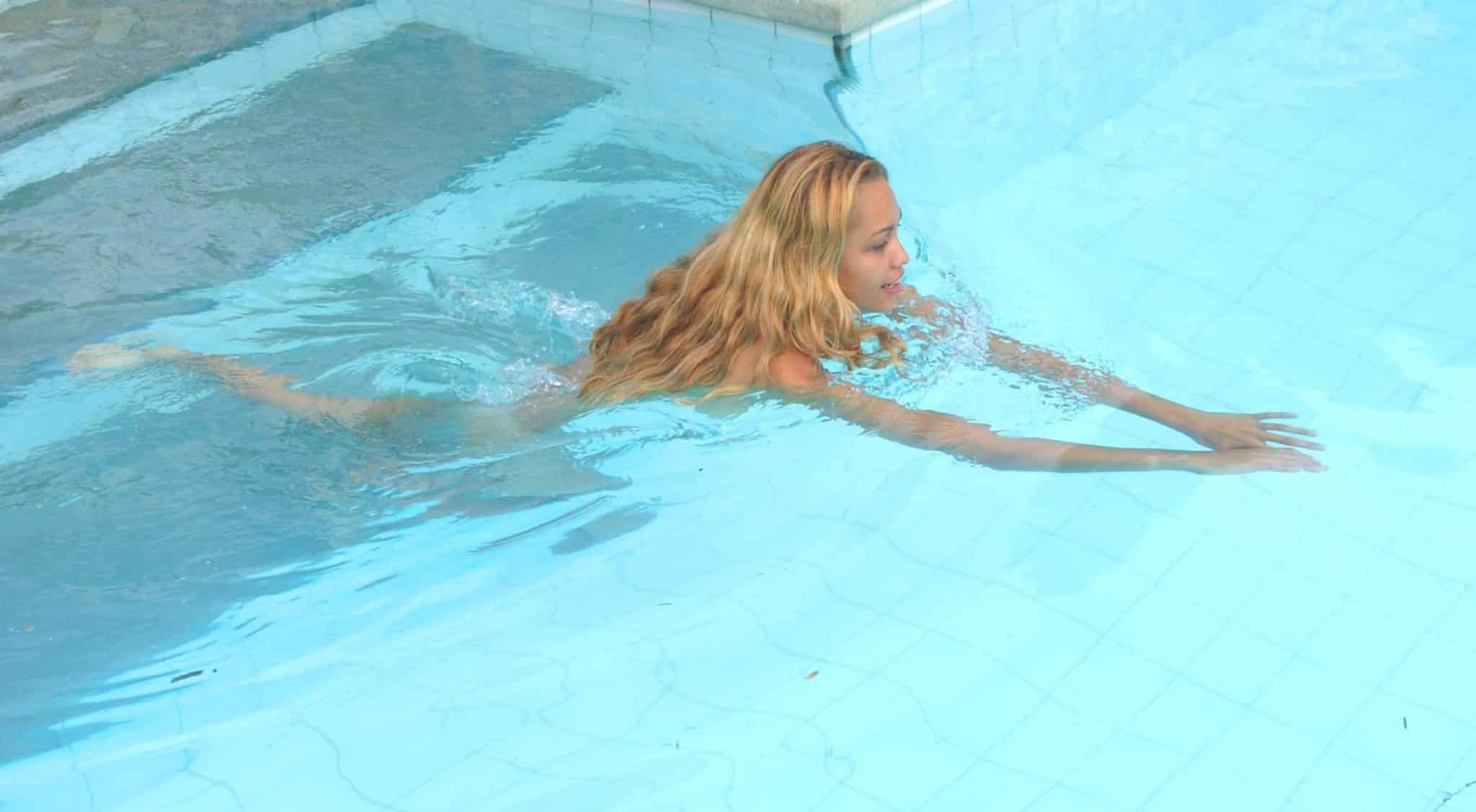 Une latina prend un bain dans la piscine pour nous réchauffer